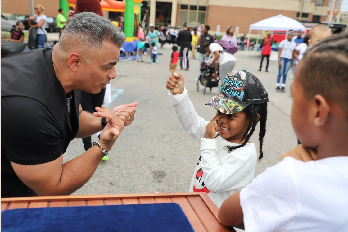 man showing young girl how to hit a t-ball