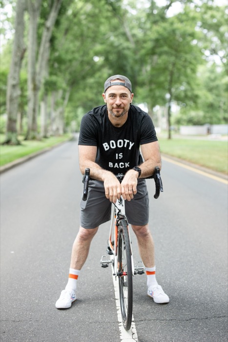 Man standing with a bicycle.