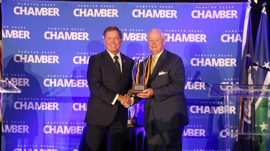 Bob Aston shaking hands with award presenter at an event.