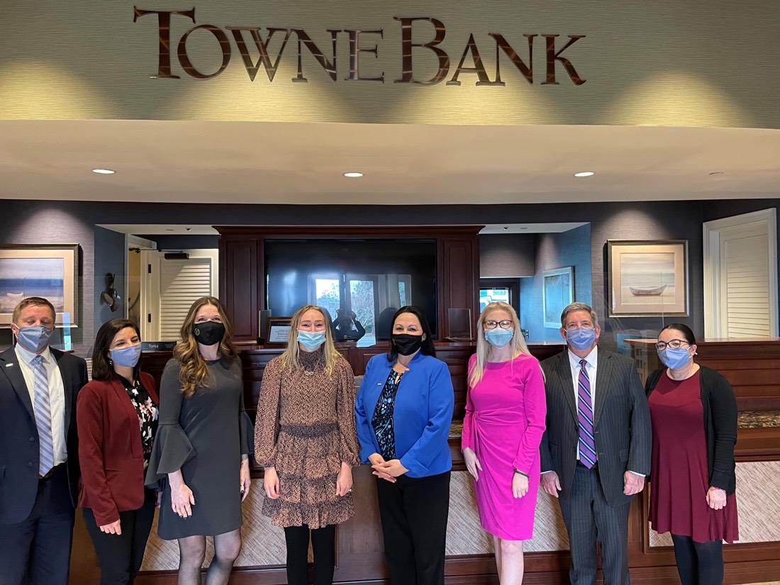 Eight people wearing face masks posing in an office.