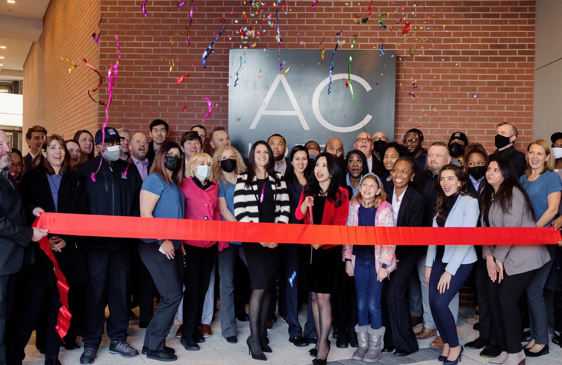 Scene of coworkers celebrating a ribbon cutting ceremony.