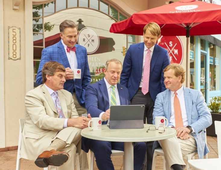 Five people gathered around an outdoor dining table.